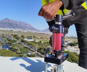 Technician performing Anchor Point Testing Cape Town using calibrated load-testing equipment on a rooftop in Durban.