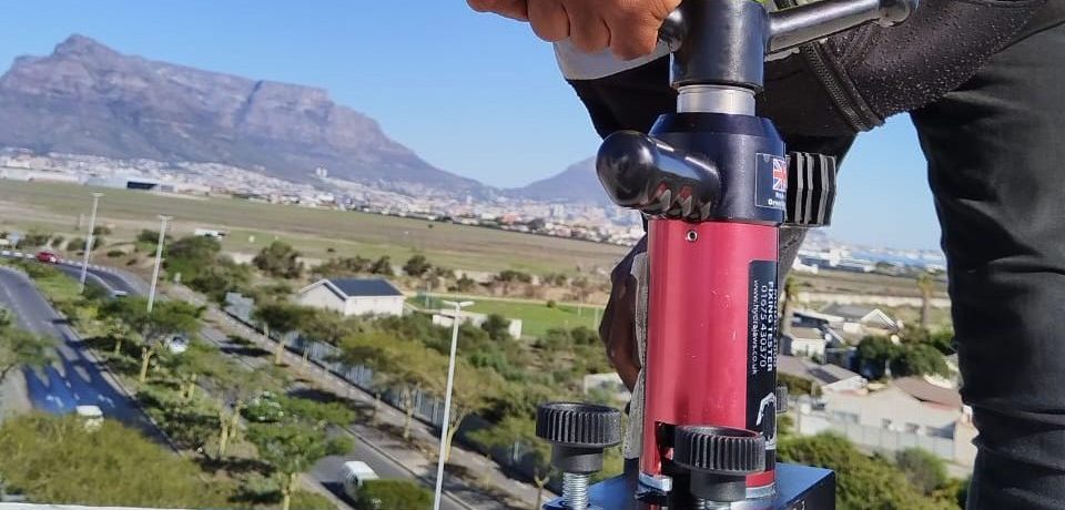 Technician performing Anchor Point Testing Cape Town using calibrated load-testing equipment on a rooftop in Durban.