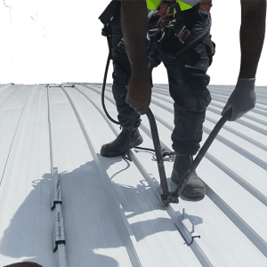 Cut out of Rope access technician installing a permanent horizontal lifeline system during roof safety installation at St Charles College in Pietermaritzburg.