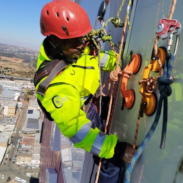 Rope Access Signage Repair Johannesburg showing technician working close to the ABSA Tower sign panel at height