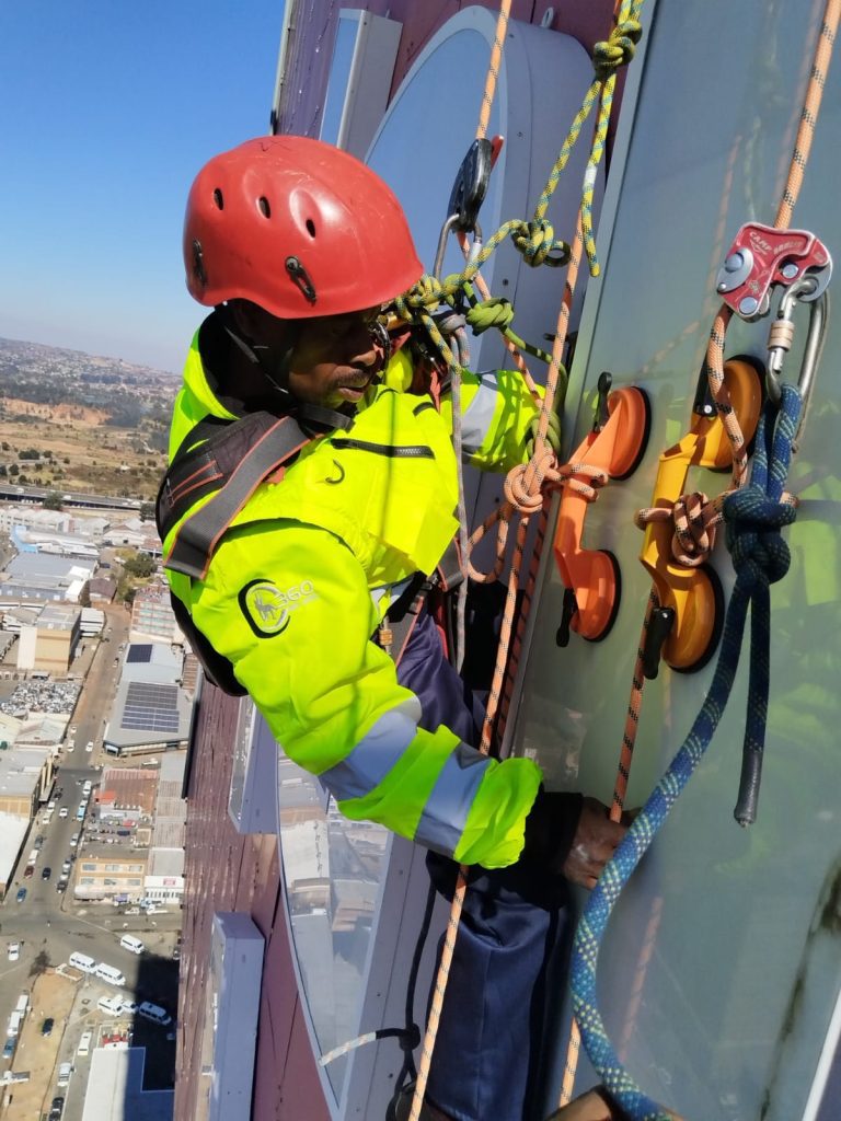 Rope Access Signage Repair Johannesburg showing technician working close to the ABSA Tower sign panel at height