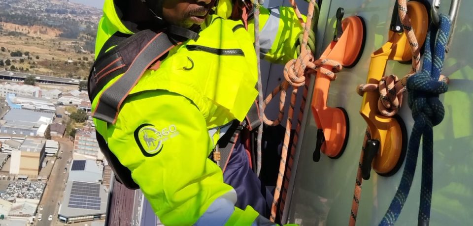 Rope Access Signage Repair Johannesburg showing technician working close to the ABSA Tower sign panel at height