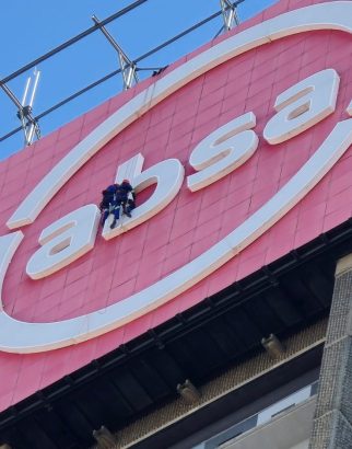 Rope Access Signage Repair Johannesburg showing technicians repairing the ABSA Tower LED sign up close