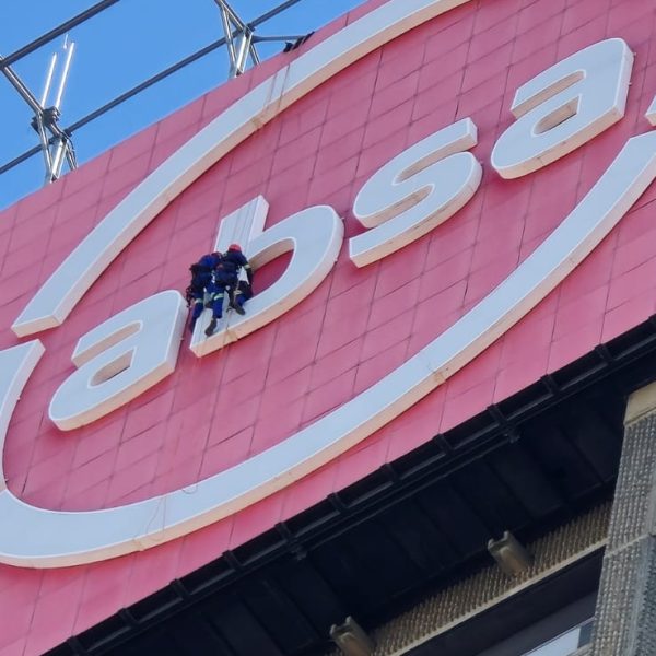 Rope Access Signage Repair Johannesburg showing technicians repairing the ABSA Tower LED sign up close