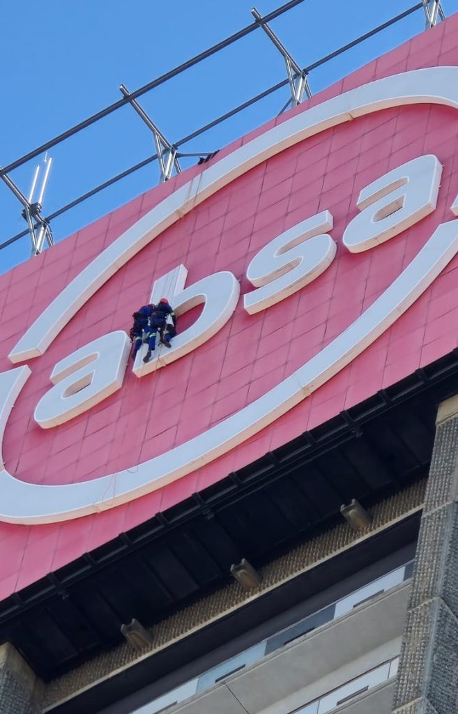 Rope Access Signage Repair Johannesburg showing technicians repairing the ABSA Tower LED sign up close. Rope Access Work Examples