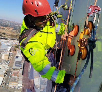 Rope Access Signage Repair Johannesburg showing technician working close to the ABSA Tower sign panel at height