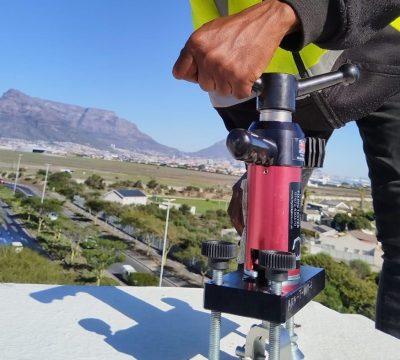 Technician performing Anchor Point Testing Cape Town using calibrated load-testing equipment on a rooftop in Durban.