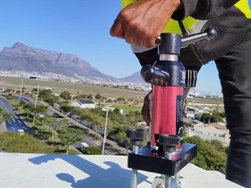 Technician performing Anchor Point Testing Cape Town using calibrated load-testing equipment on a rooftop in Durban.