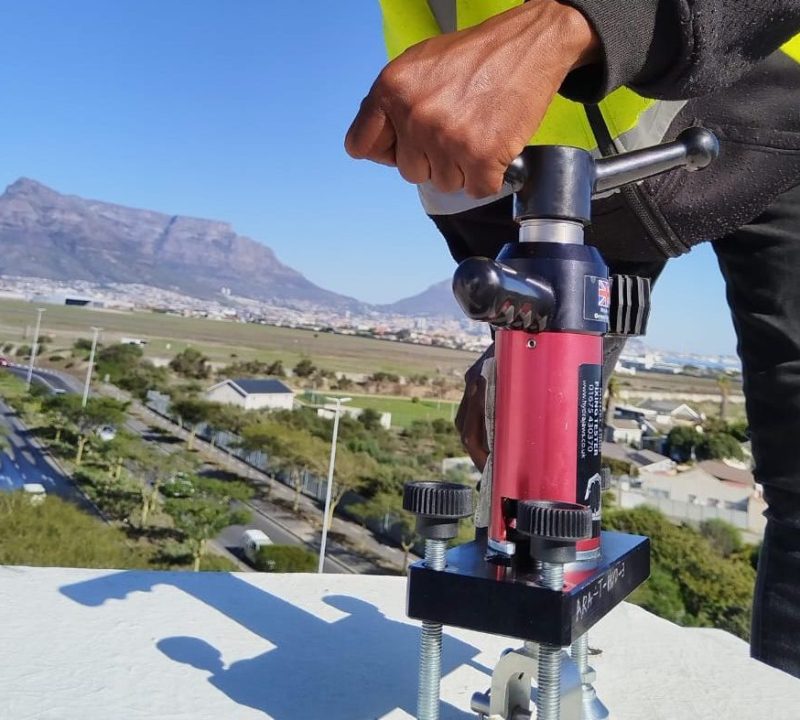 Technician performing Anchor Point Testing Cape Town using calibrated load-testing equipment on a rooftop in Durban.