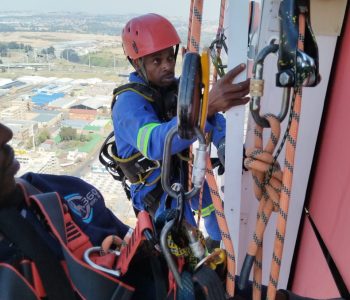 Rope Access Signage Repair Johannesburg with technicians working together on the ABSA Tower sign