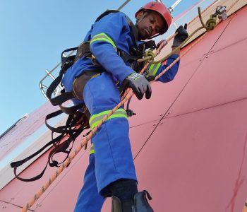 Rope Access Signage Repair Johannesburg showing technician working underneath the ABSA Tower sign structure