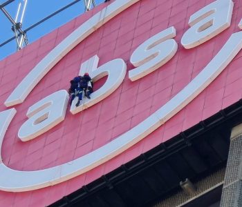 Rope Access Signage Repair Johannesburg showing technicians repairing the ABSA Tower LED sign up close