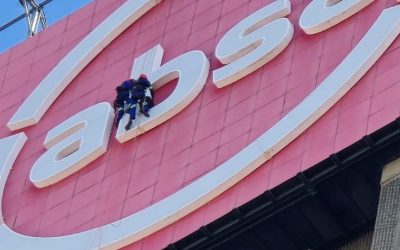 Rope Access Signage Repair Johannesburg showing technicians repairing the ABSA Tower LED sign up close