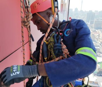 Rope Access Signage Repair Johannesburg showing technician inspecting and repairing the ABSA Tower sign at height